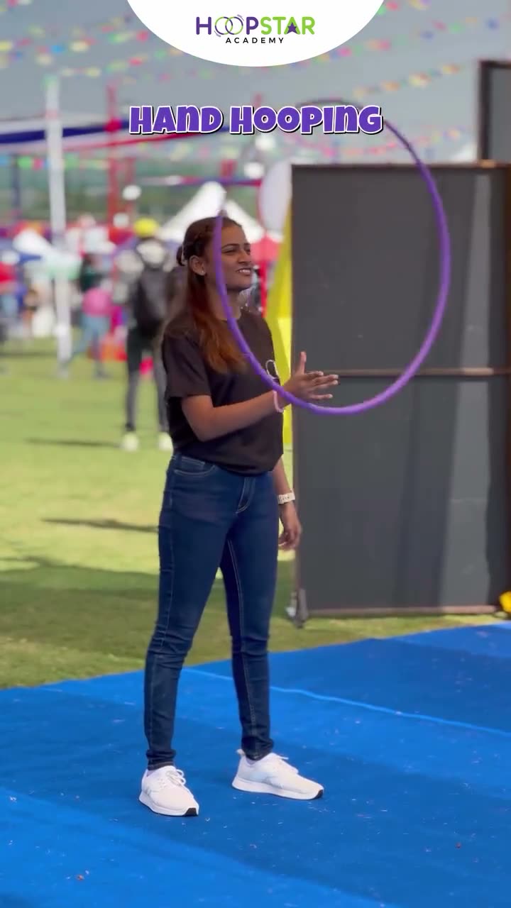 A child demonstrating Front Hand Hooping — a Level 1 hula hoop skill