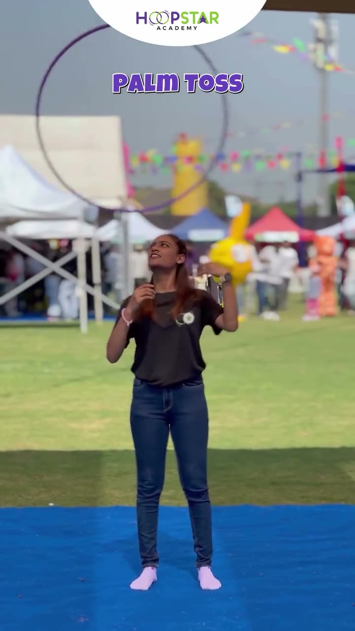 A child demonstrating Palm Toss — a Level 2 hula hoop skill