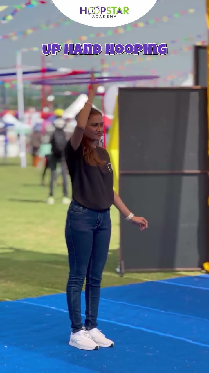 A child demonstrating Up Hand Hooping — a Level 1 hula hoop skill